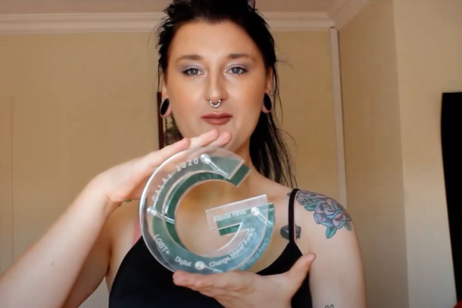Alexis Riva holding a transparent circular GALA 2020 Change Maker Award, filmed indoors during her YouTube video.
