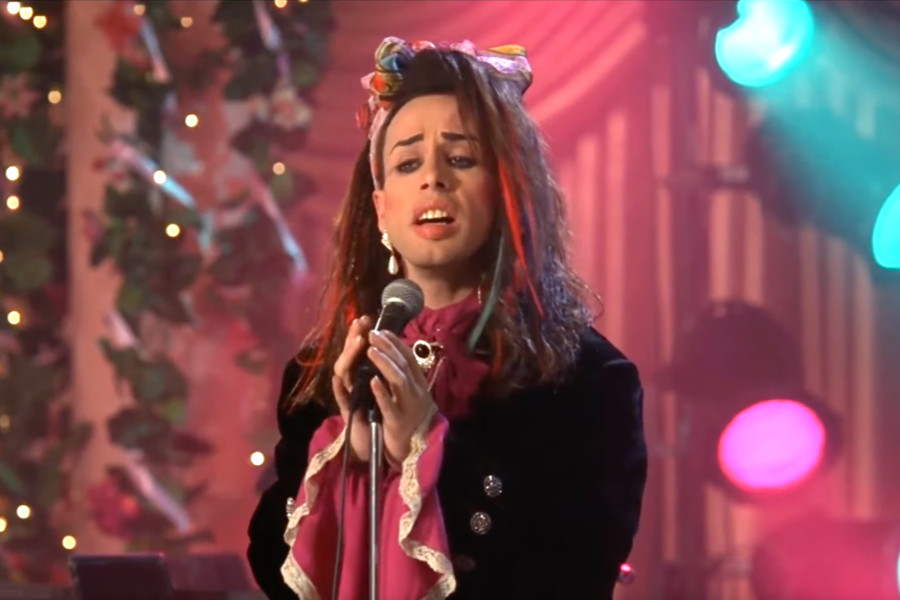 Alexis Arquette performs Do You Really Want to Hurt Me onstage in a colorful 80s-themed set in The Wedding Singer (1998).