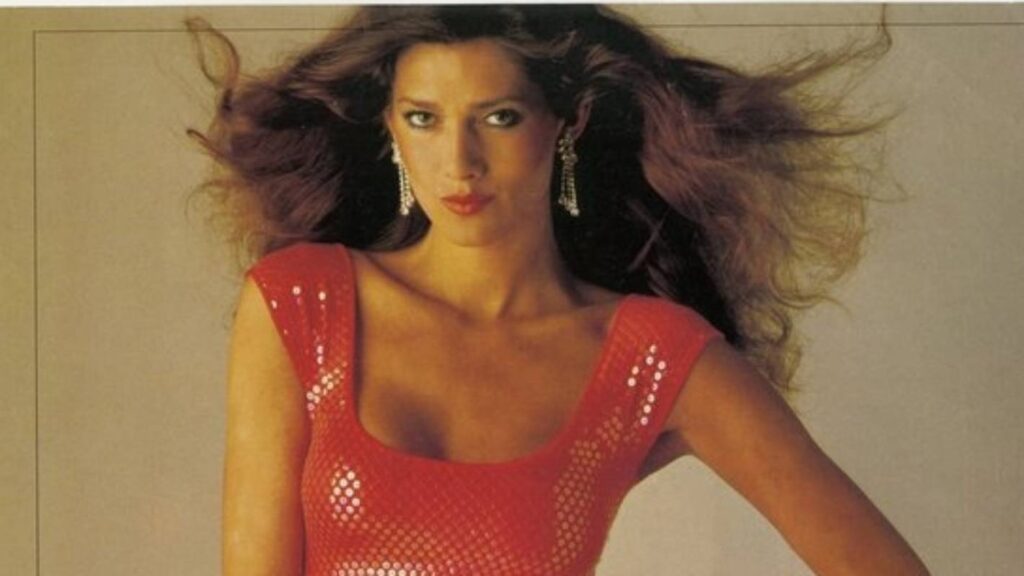 Model Caroline Cossey with voluminous hair in a red sequin dress, part of an Australian print ad for Jane Caitlin.