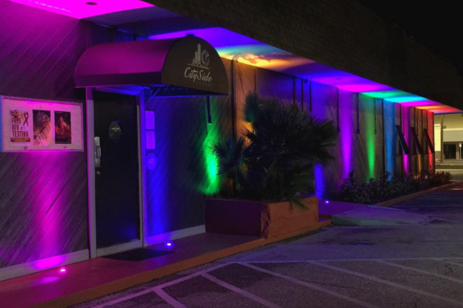 Colorfully lit exterior of City Side Lounge, a welcoming LGBT bar in Tampa, Florida, seen at night.
