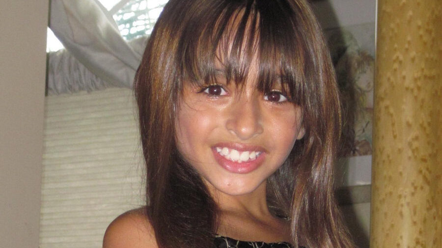 A childhood photo of Jazz Jennings smiling in a patterned dress, shared as part of the 2010 decade challenge.