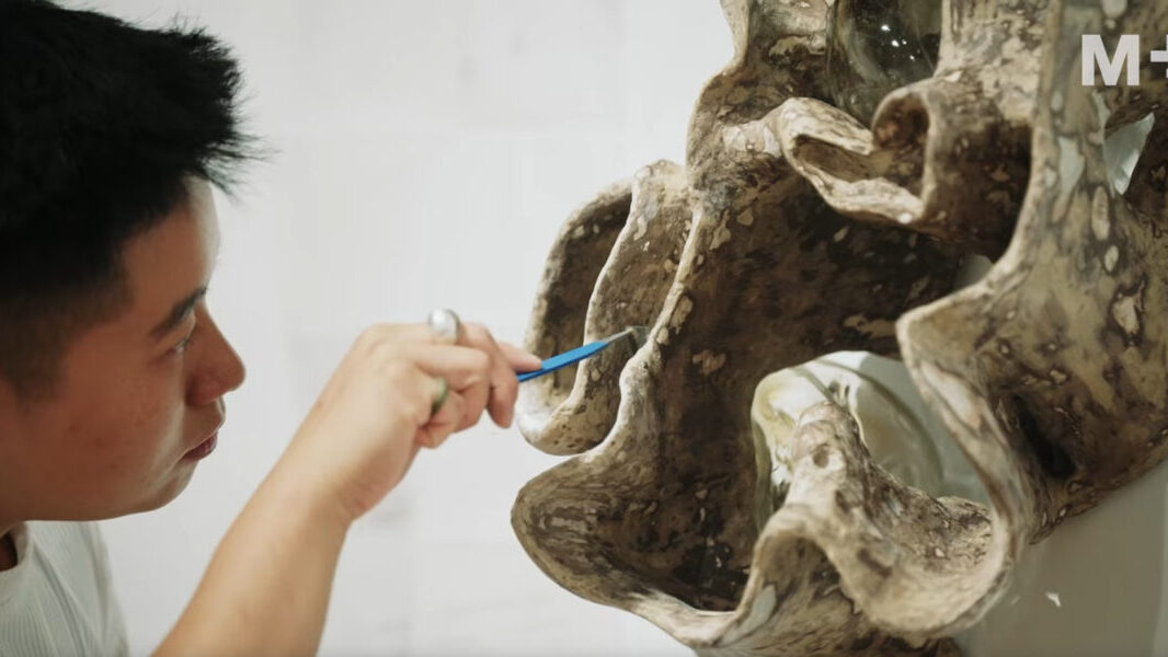 Artist Jes Fan uses a tool to refine an organic sculpture for his “Beyond Appearances” feature at the M+ Museum.