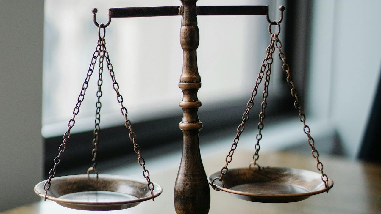 Balance ancienne en laiton équilibrée avec des plateaux peu profonds, placée à l'intérieur près d'une fenêtre.