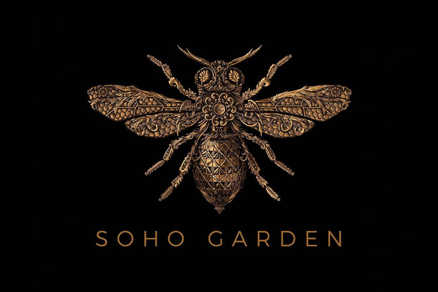 Detailed golden bee emblem with ornate patterns on black background, logo of Soho Garden nightclub in Dubai.