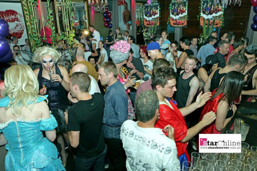 Colorful party at The Stonewall Hotel with guests in costumes and drag performers.
