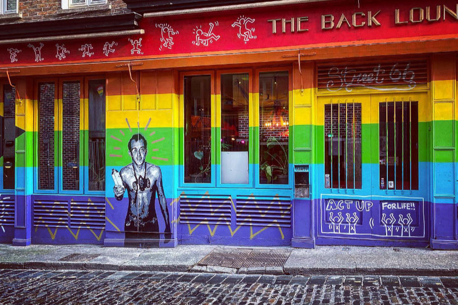 Rainbow-painted facade of Street 66 in Dublin with Keith Haring-style art and queer activist murals.