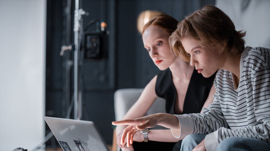 Two women focused on a computer screen in an office, symbolizing professional inclusion.