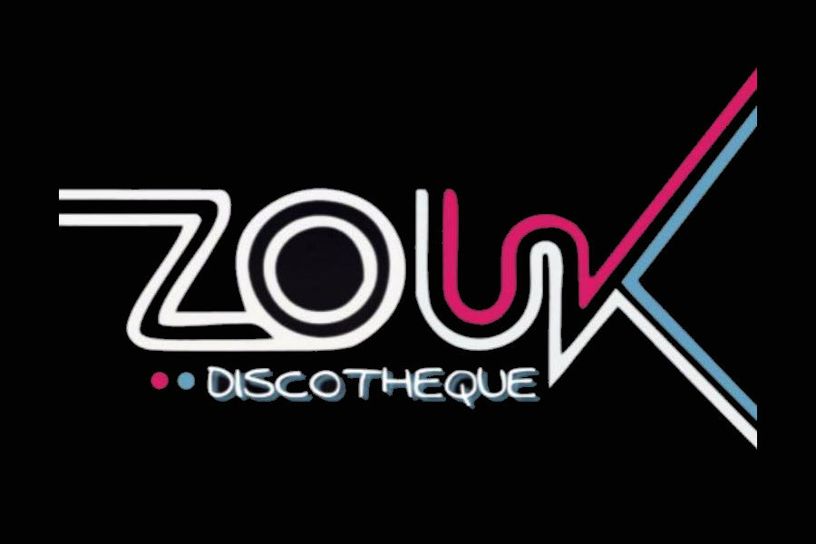 Logo estilizado de Zouk en neón llamativo sobre una multitud desenfocada en un club nocturno.